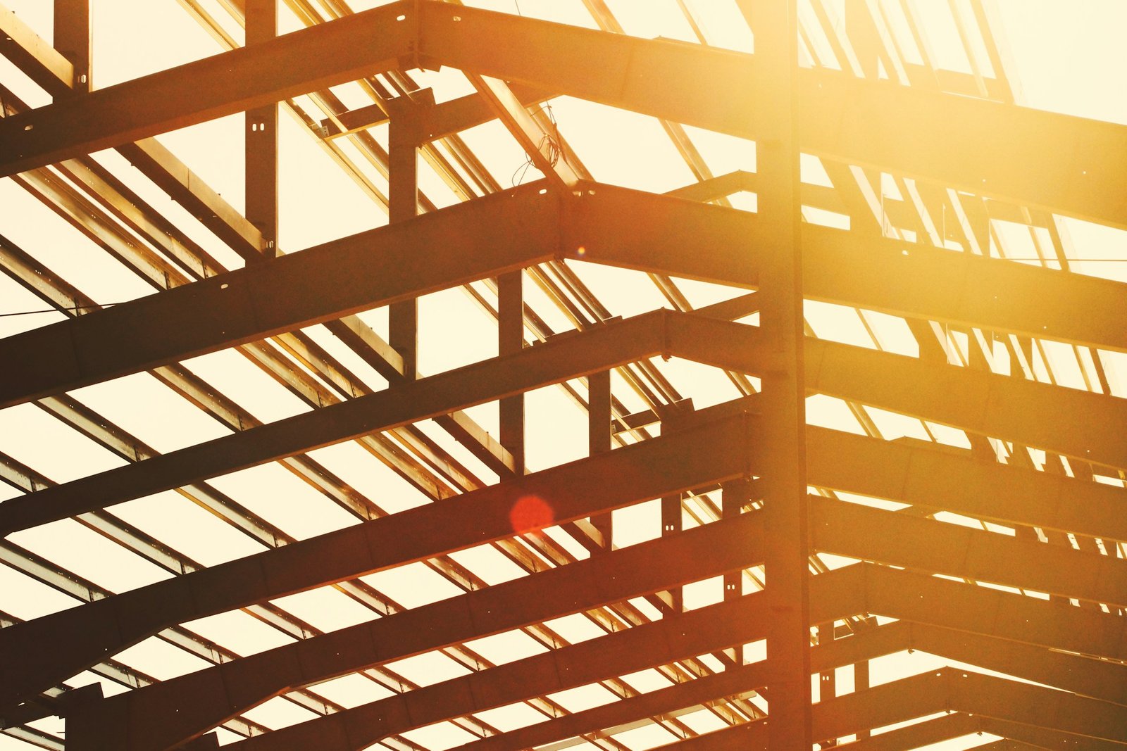 Sunlit steel beams forming a building roof structure